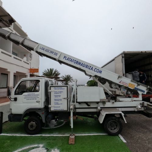 El camión de nuestra empresa con la plataforma para elevación de muebles desplegada